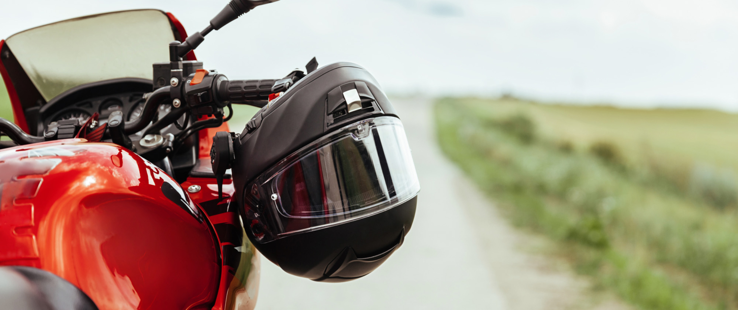 Black motorcycle helmet hanging on the handlebars of the motorcycle