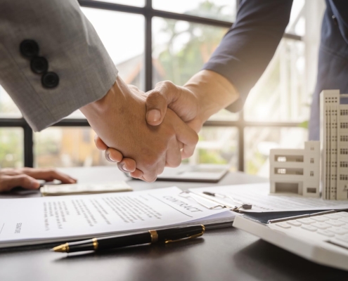 Two business people shaking hands on commercial property insurance