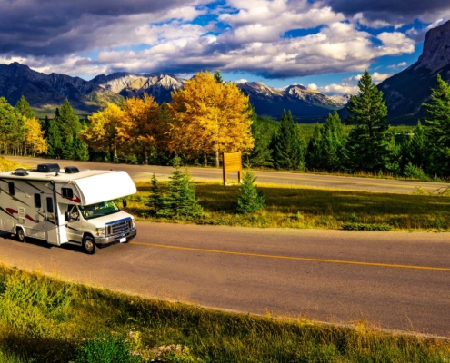 Recreational Vehicle Driving on Autumn Highway In Beautiful Mountains Wilderness