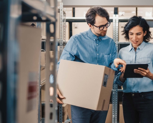 Two workers in retail breakroom looking at inventory
