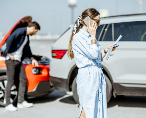 Person on phone with insurance infront of car wreck