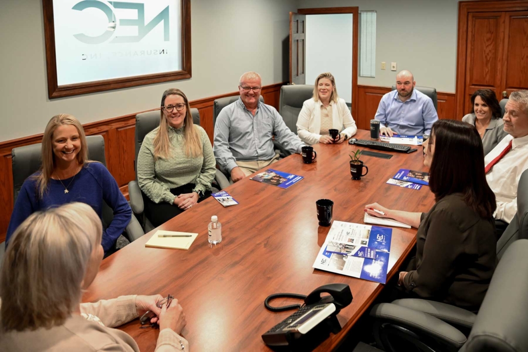 Leadership team at NEC sitting at the conference table